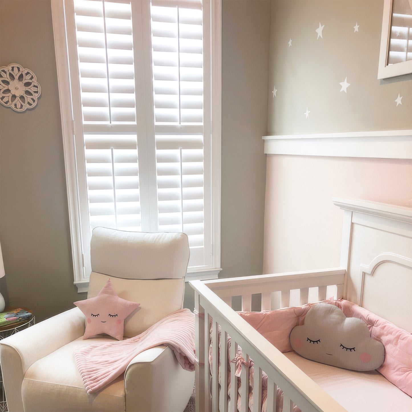 Nursery room with a crib, chair, and decorative pillows.