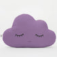 Purple cloud-shaped throw pillow, closed eyes and small smile – plain white background.