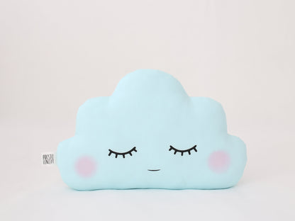 Light blue cloud-shaped throw pillow, closed eyes and pink cheeks – white background.
