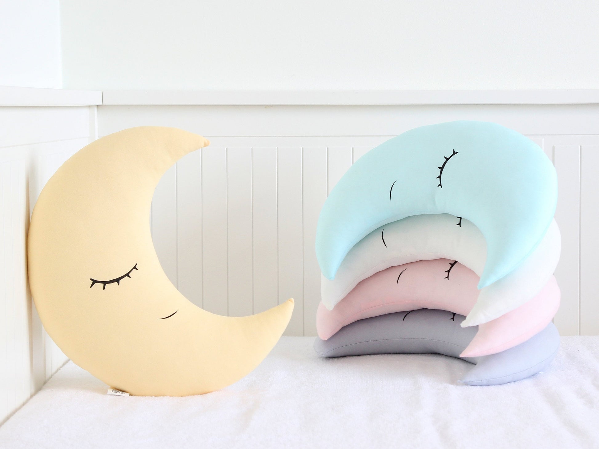 Crescent-shaped throw pillow, closed-eye design – shown on a white surface.