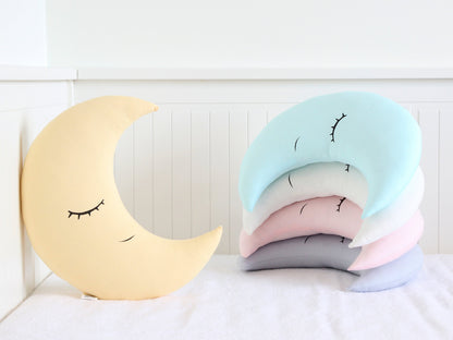 Crescent-shaped throw pillow, closed-eye design – shown on a white surface.